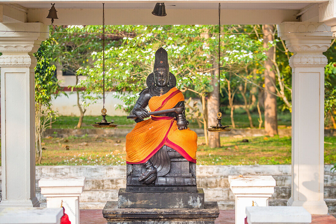Hindu-Schrein mit einer in orangefarbene Seide eingewickelten Götterstatue im ländlichen Dorf auf dem CGH Earth Grundstück von Mantra Koodam in Kumbakonam; Tamil Nadu, Indien