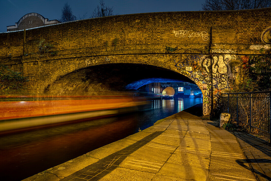 Bridge crossing Regent's Canal at Shoreditch with streaking lights at night; London, England