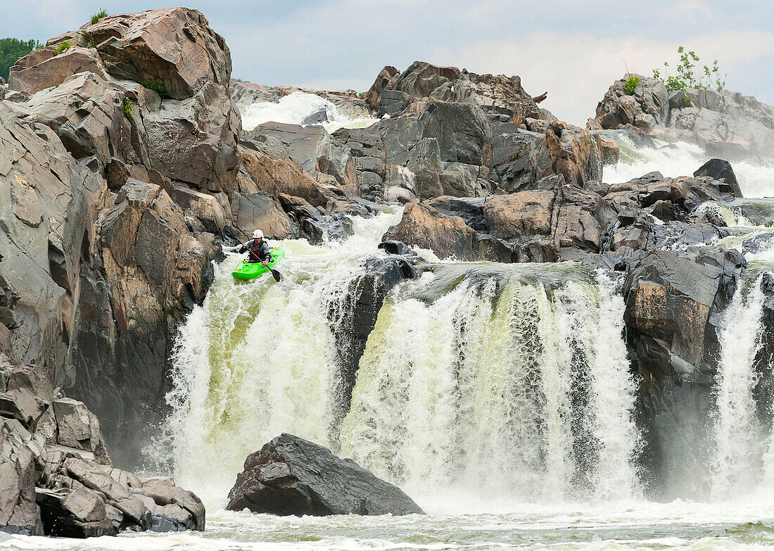A kayaker paddles over Great Falls waterfall in Great Falls, Virginia.
