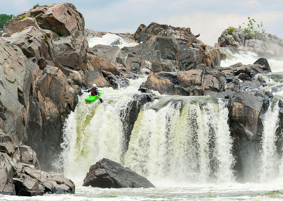 Ein Kajakfahrer paddelt über den Great Falls Wasserfall in Great Falls, Virginia.