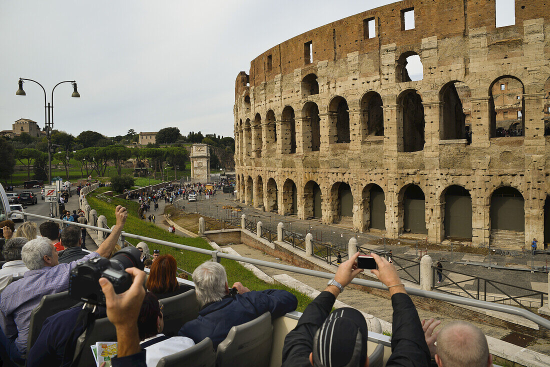 Blick von hinten auf Touristen in einem Reisebus, die das Kolosseum fotografieren; Rom, Latium, Italien