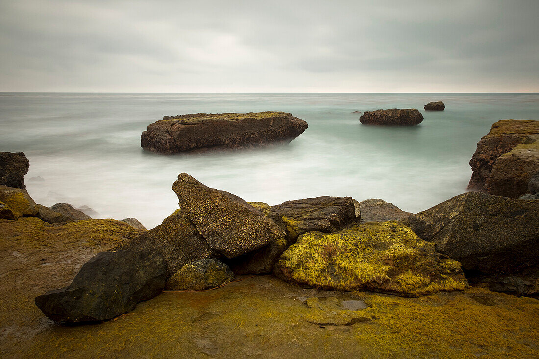 A long exposure seascape made along a rocky beach in Santa Cruz; Santa Cruz, California, United States of America