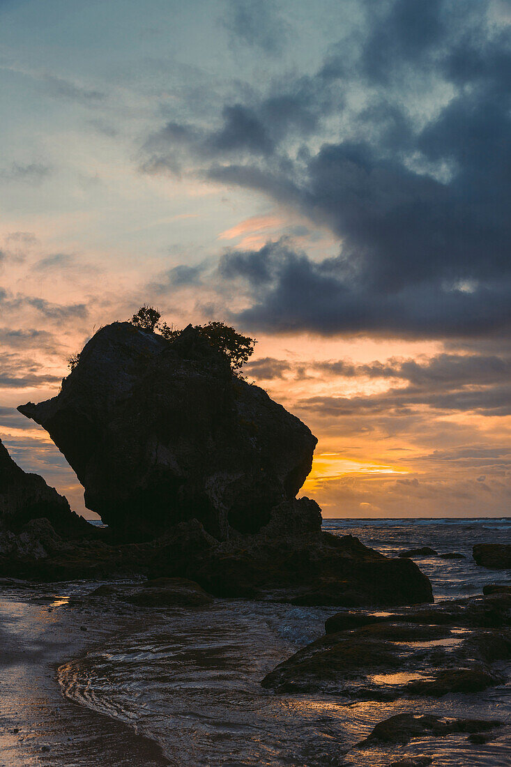 Silhouette of large rock formation and coastline of Diamond Beach at twilight, Nusa Penida, Bali, Indonesia; Nusa Penida, Bali, Indonesia