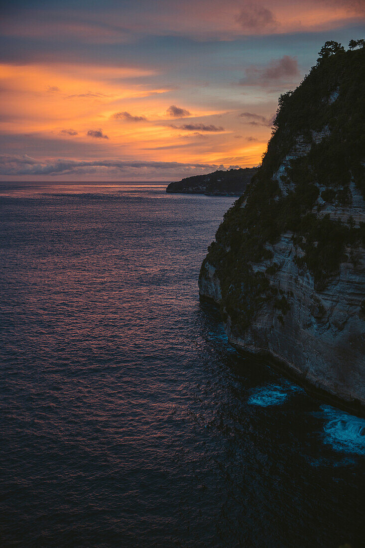 Sunset over ocean with sea cliffs at Diamond Beach, Nusa Penida, Bali, Indonesia; Nusa Penida, Bali, Indonesia