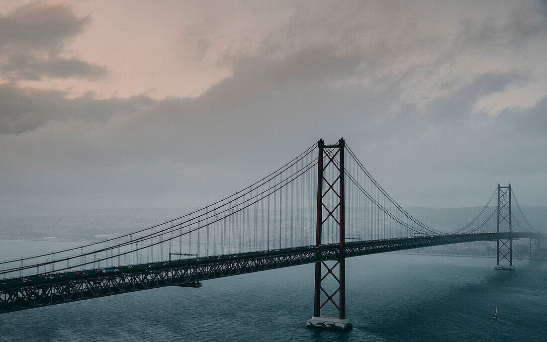 Die Brücke 25 de Abril über den Tejo, die Lissabon und Almada verbindet, an einem grauen, nebligen Tag; Lissabon, Estremadura, Portugal