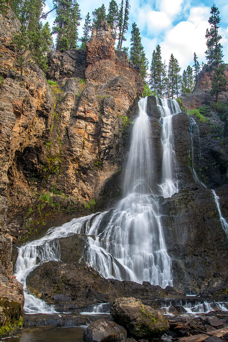 Crystal Falls flowing over the cliffs, created by the outfall of Cascade Creek in Yellowstone National Park; Wyoming, United States of America