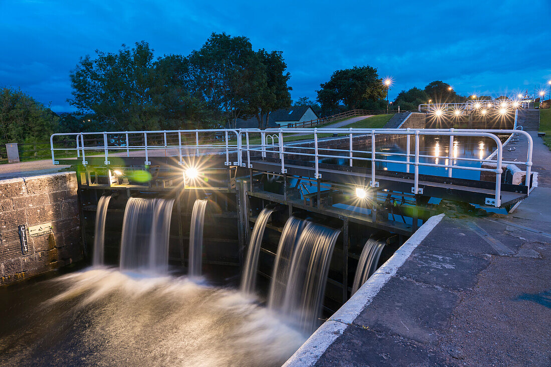 At dusk, lights illuminate the Caledonian Canal locks in Inverness, Scotland; Inverness, Scotland