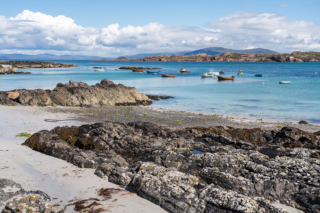 Boote treiben in der Nähe der felsigen Küste der Insel Iona, Schottland; Iona, Schottland