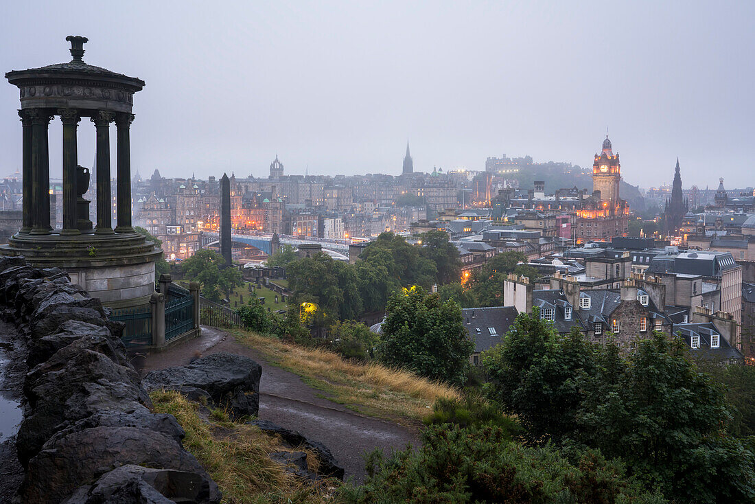 In der Abenddämmerung, ein Blick auf die Innenstadt von Edinburgh, Schottland und Edinburgh Castle und das Balmoral Hotel vom Calton Hill; Edinburgh, Schottland