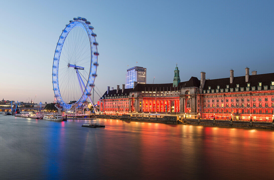 London Eye along the River Thames at sunset in London, England.