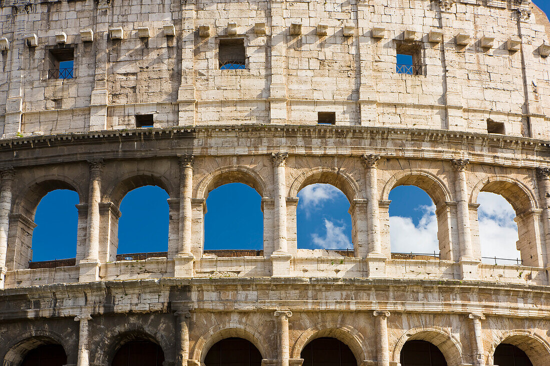 Detail der Außenansicht des berühmten Kolosseums vor blauem Himmel; Rom, Latium, Italien