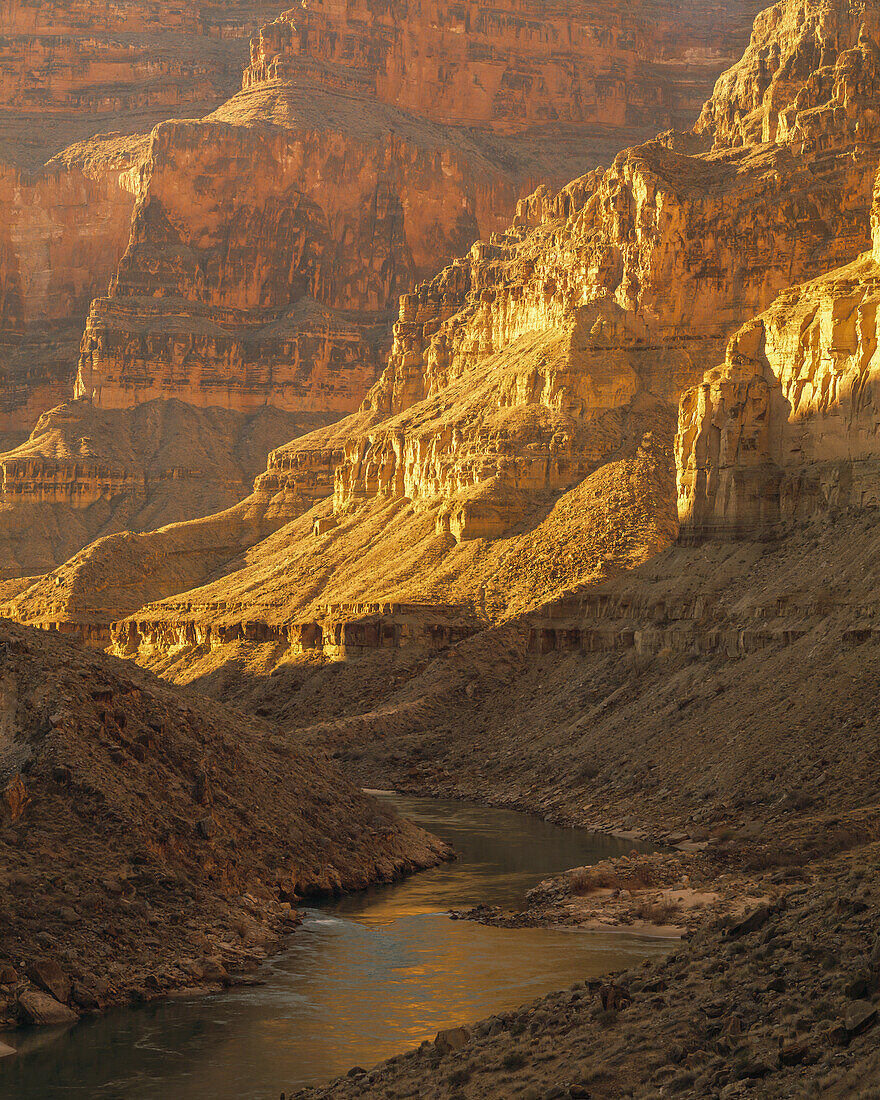 The Colorado River flowing through limestone cliff flanked canyon.