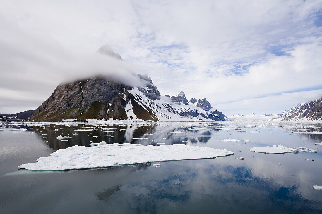 Clouds are reflected in clear arctic waters.