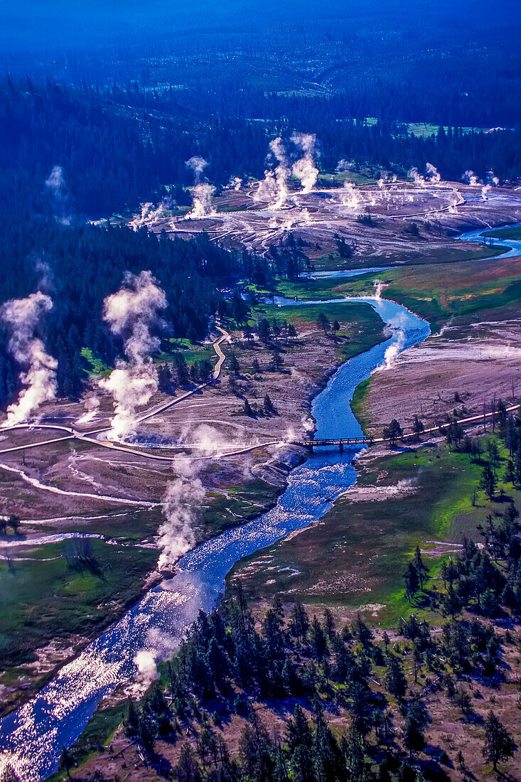 Aerial view of the columns of steam and the water released from the various hot springs and geysers with its numerous runoff channels draining northward along the Firehole River and the thousands of thermal features of the Lower Geyser Basin, the largest geyser complex in the world; Yellowstone National Park, Wyoming, United States of America