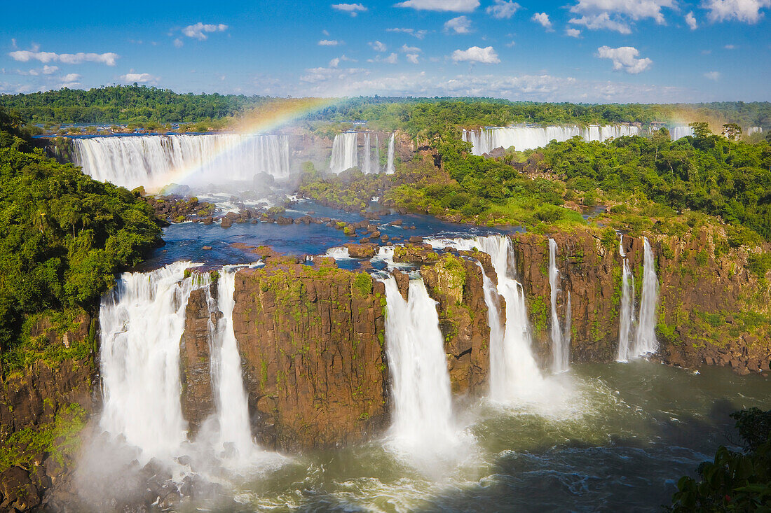 Overview of a rainbow arching over the iconic Iguazu Falls, Iguazu Falls National Park; Parana, Brazil