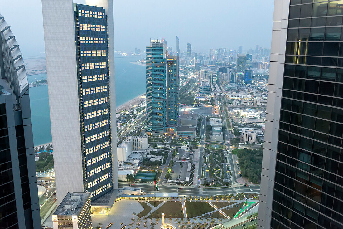 Blick über die Corniche Road auf den ADNOC Tower und die Nation Towers in der Abenddämmerung in Abu Dhabi City; Abu Dhabi, Vereinigte Arabische Emirate