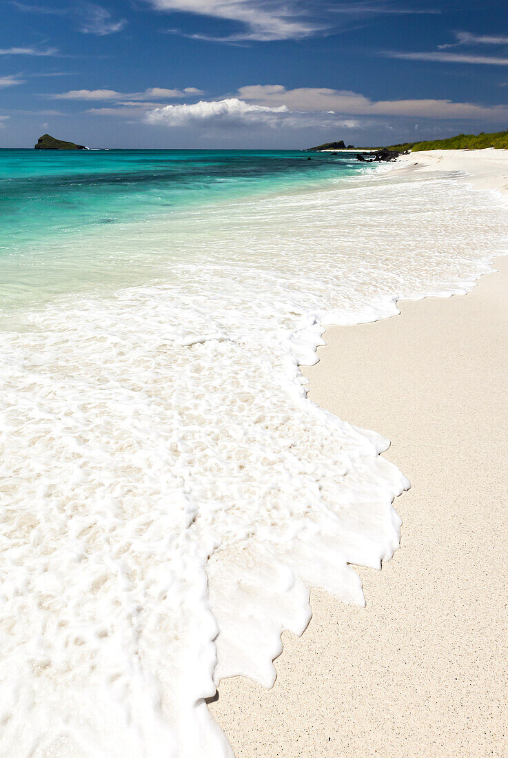 Brandung an einem weißen Korallensandstrand.