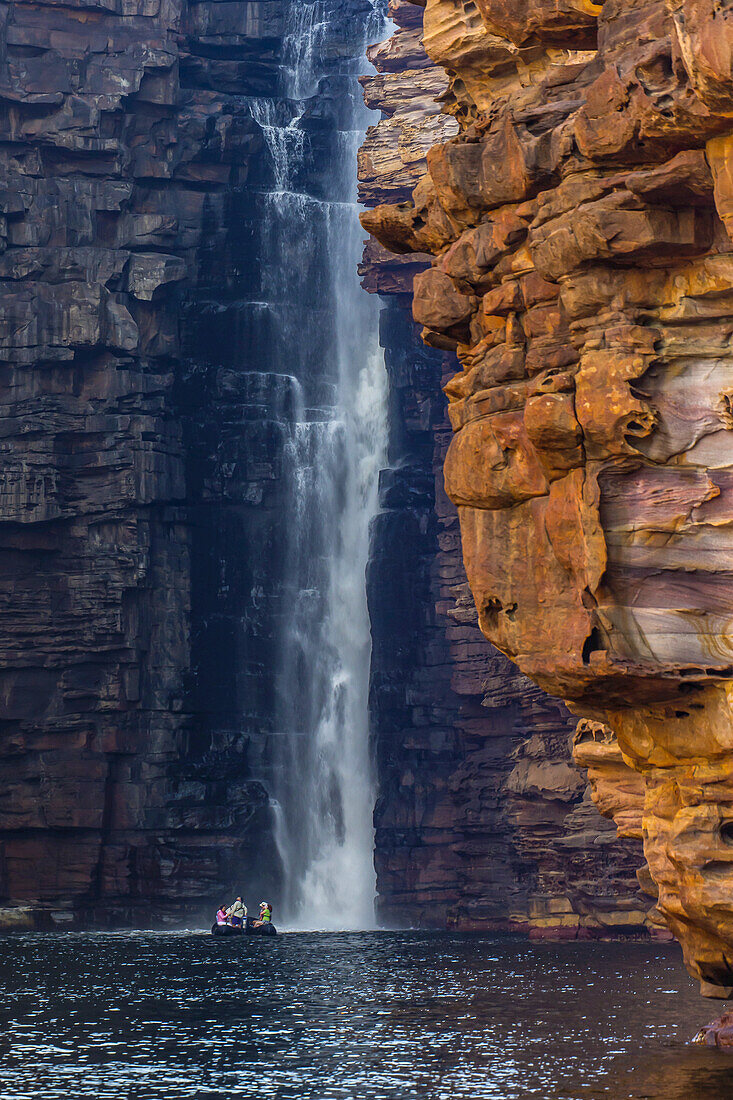 Ein Boot am Fuße eines Wasserfalls bei den King George Falls in der Nähe der Koolama Bay in der Kimberley Region im Nordwesten Australiens.