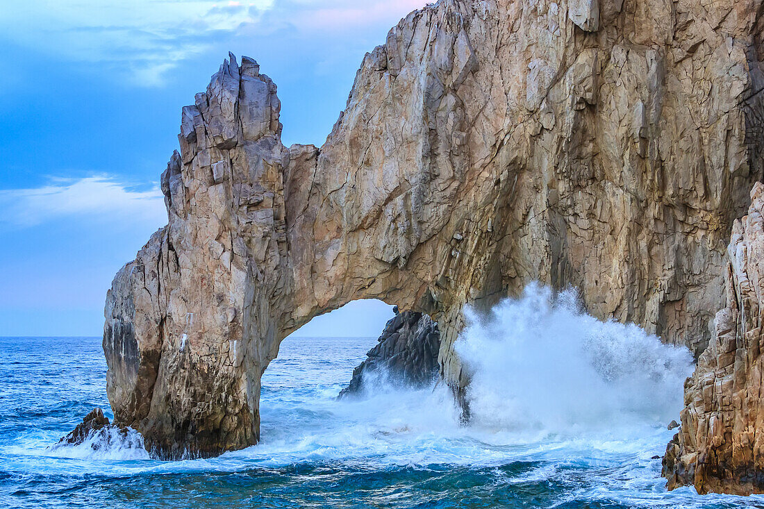 Wellen schlagen gegen die Felsen am berühmten Bogen Los Arcos in Lands End.