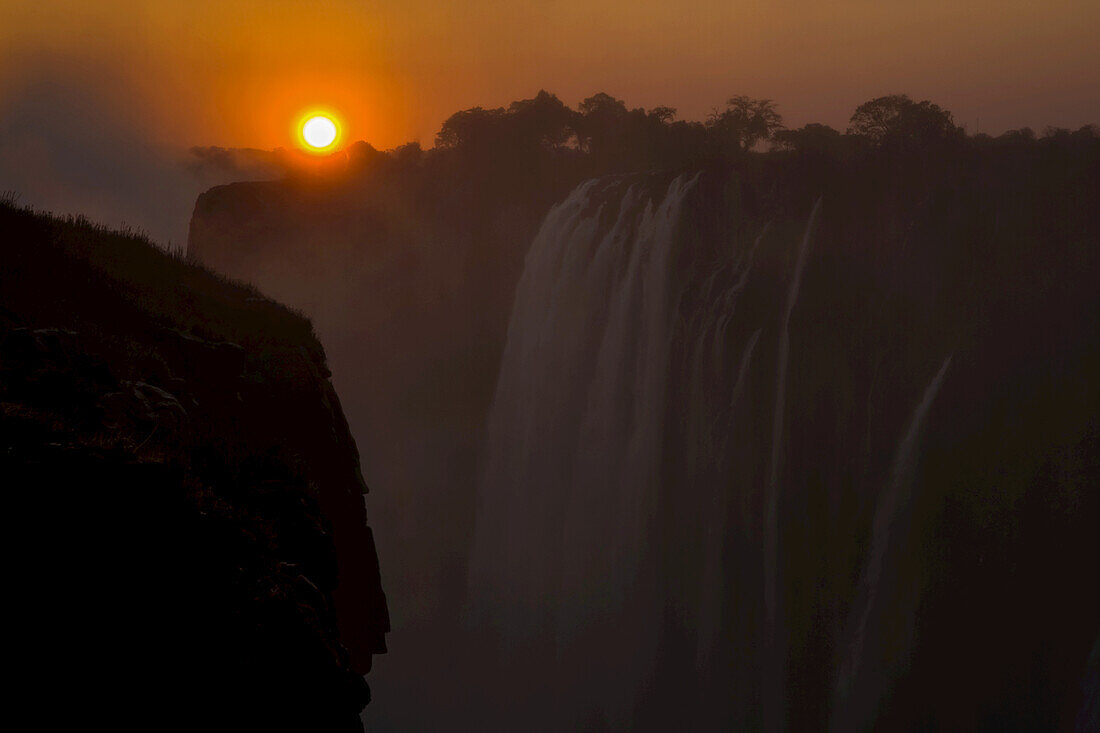Sunset over cascading Victoria Falls.