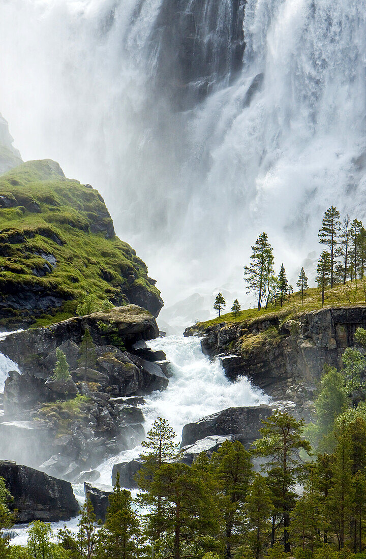 Die Wassermassen eines Wasserfalls ergießen sich über eine felsige Landschaft.