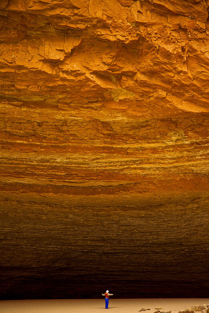Person dwarfed by massive Redwall Cavern on the Colorado River.