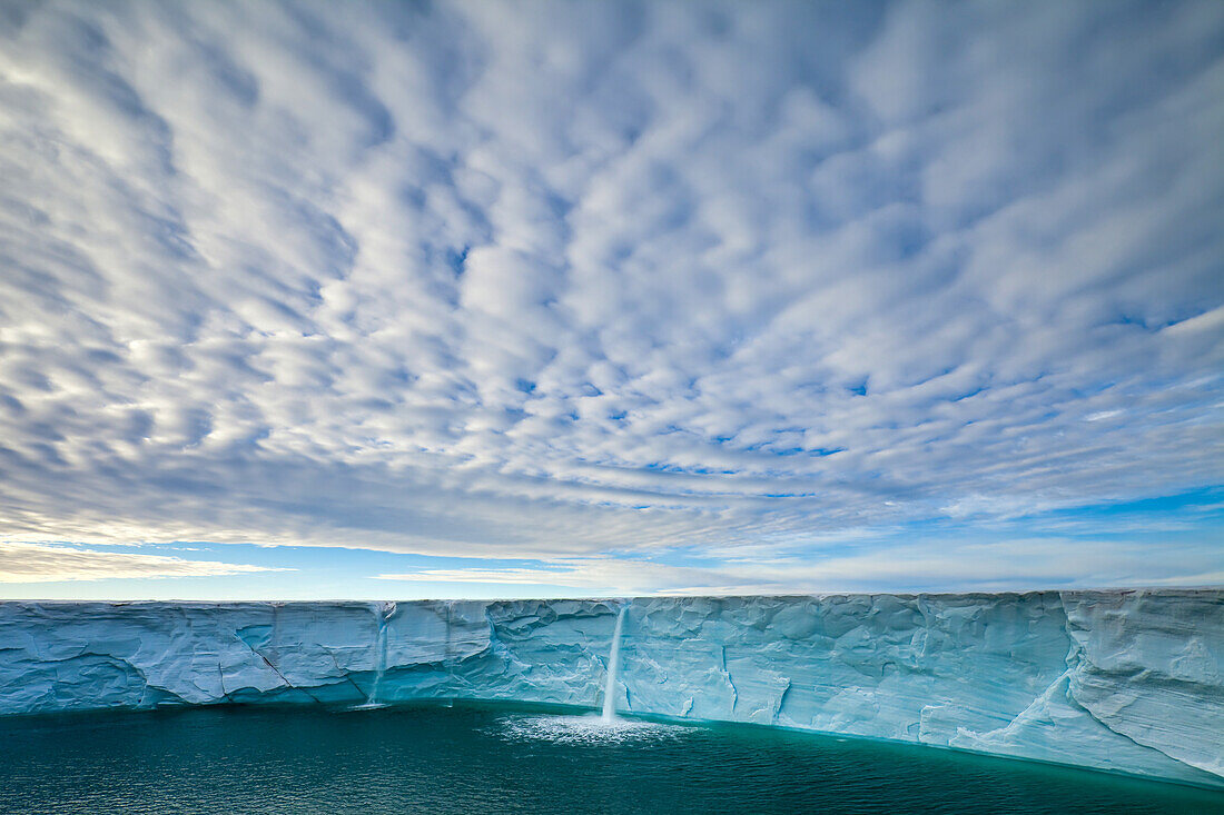 Summer meltwater forms waterfalls on an icecap.