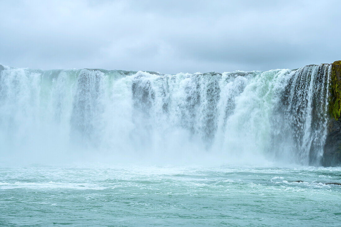 Godafoss Waterfall of the Skjálfandafljót River with a grey, cloudy sky; Fossholl, Nordurland Eystra, Iceland