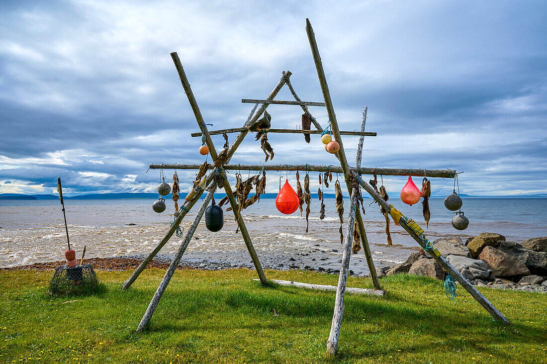 Wood poles frame with flotsam and dry fish along the coastal shore of the North Atlantic Ocean at Vatnsnes Peninsula in the Northern Region of Iceland; Vatnsnes Peninsula, Nordurland Vestra, Iceland