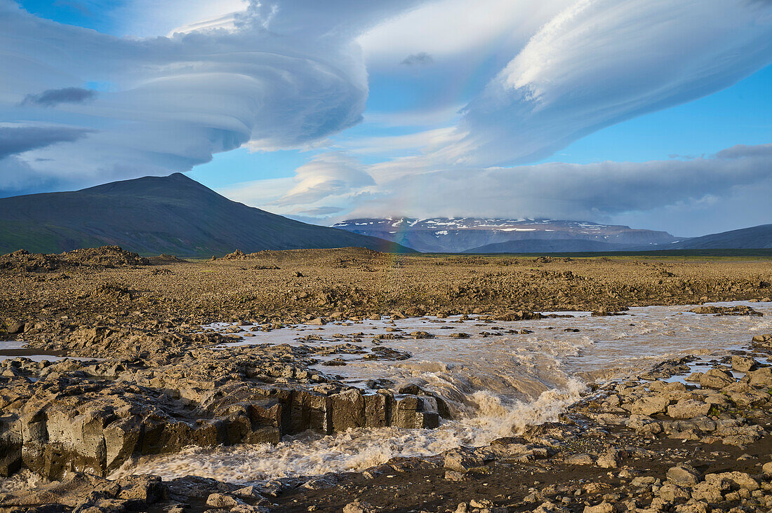 Gletscherfluss fließt durch die Basaltlandschaft mit einem dramatischen Wolkenhimmel entlang des Kaldidalur-Tals; Husafell, Nordurland Vestra, Island