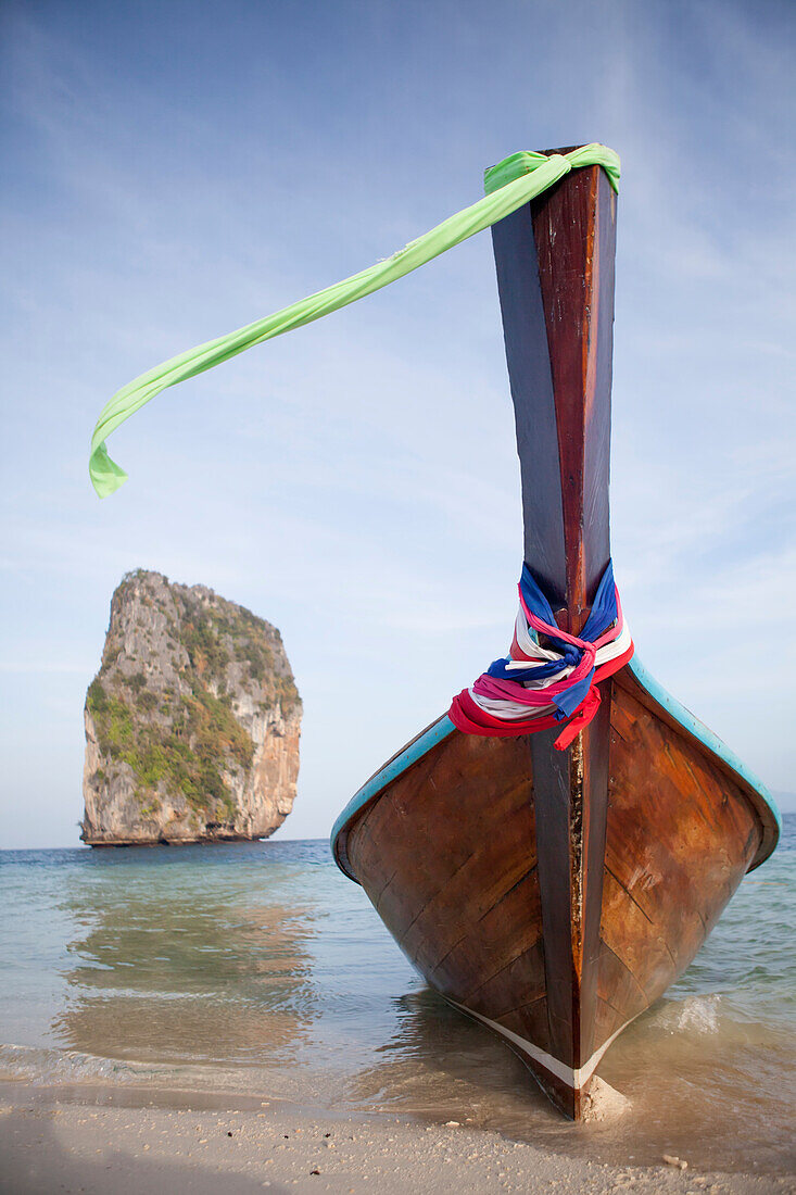 A long tail boat and a limestone karst in Krabi, Thailand.