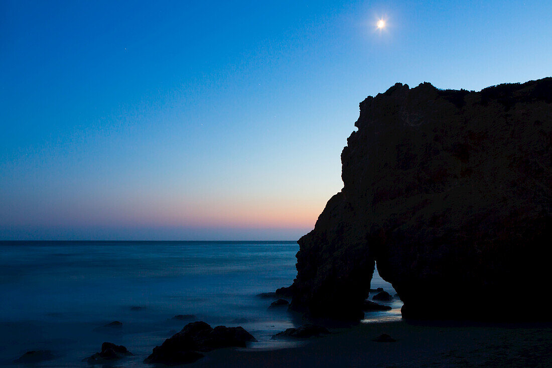 Der Mond über Felsformationen entlang des El Matador State Beach bei Nacht; Malibu, Kalifornien, Vereinigte Staaten von Amerika