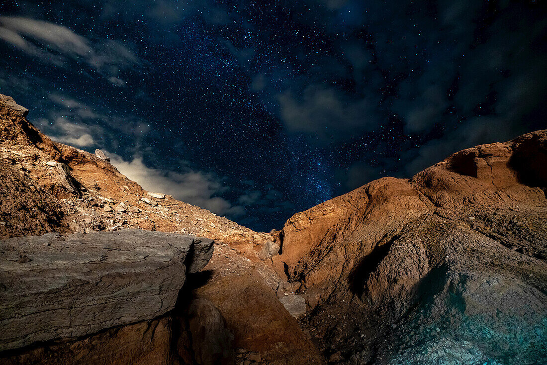 Stars in the night sky above a rocky ravine in the Atacama Desert; San Pedro De Atacama, Chile