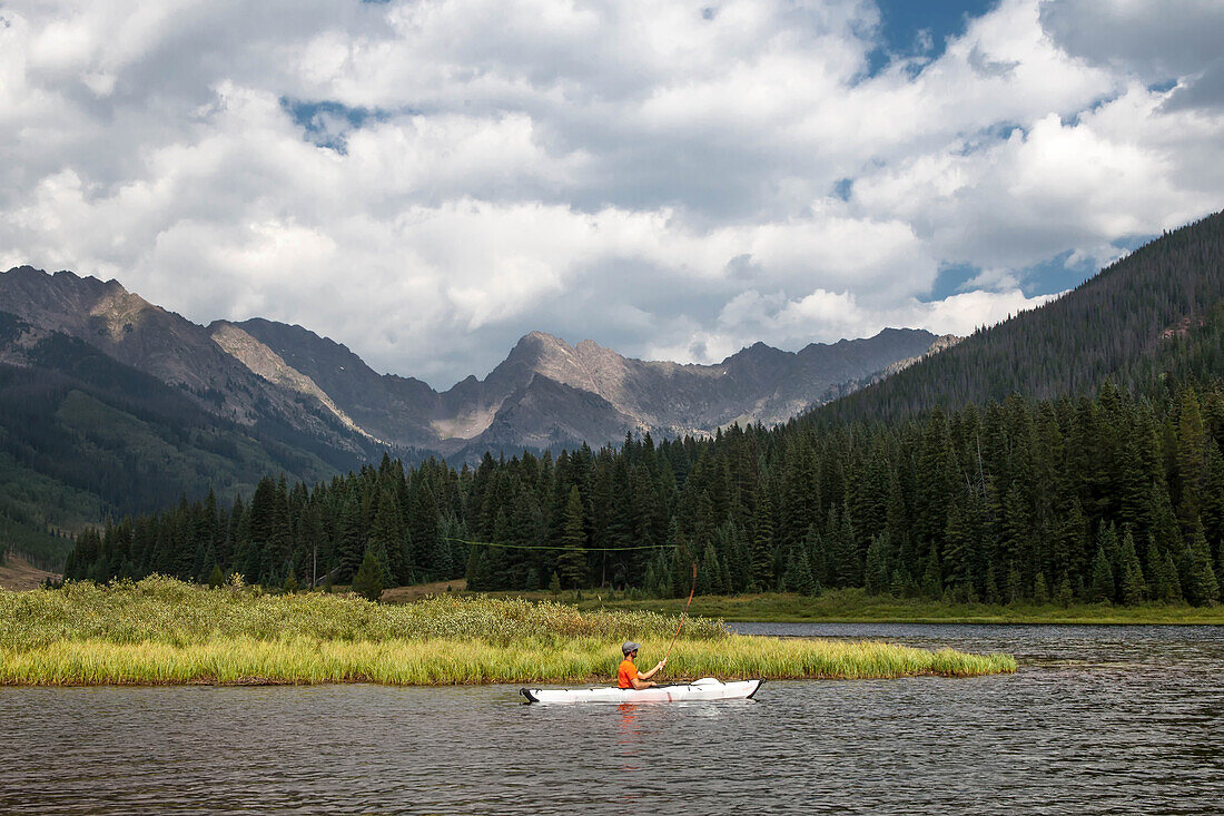 A man fly fishing from a kayak in Piney Lake, Colorado.