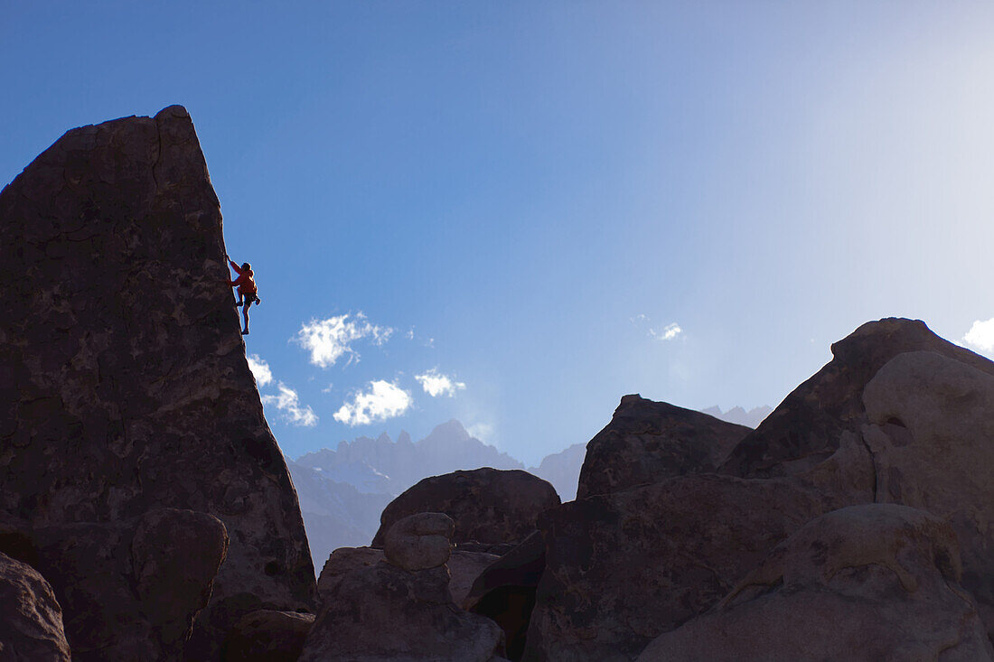 A climber on the 'Sharks Fin' formation; Mt. Whitney in the background.