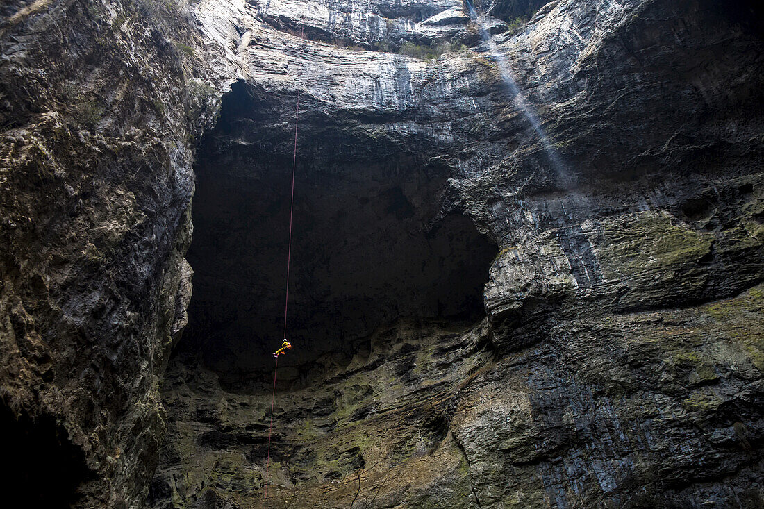 Eine Frau seilt sich in ein 600 Fuß tiefes Sinkloch in China ab