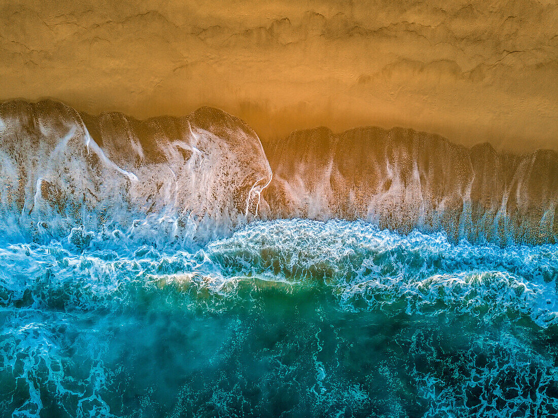 An aerial view of waves crashing against the Baja coastline.
