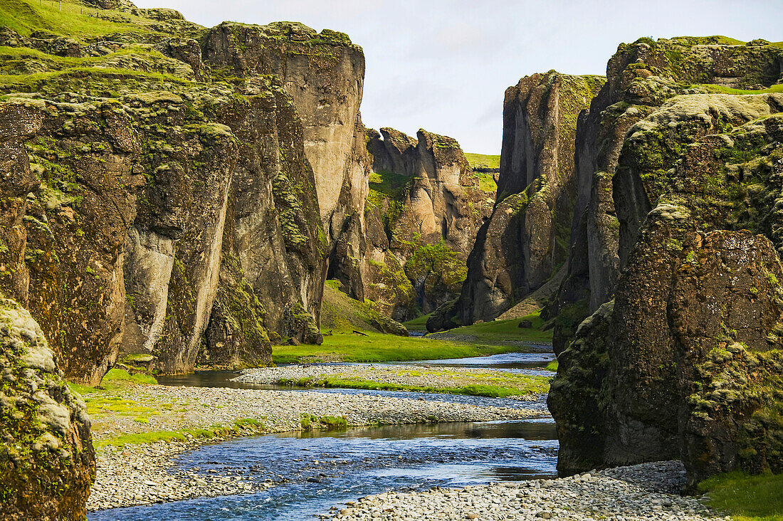 Ein Fluss, der durch eine Schlucht aus Vulkangestein im Süden Islands fließt; Fjadrargljufur-Schlucht, bei Kirkjubaejarklaustur, Island.