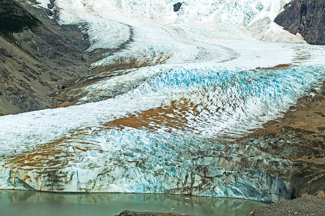 An Andean glacier flows into a Patagonian lake, Glaciar Torre flowing down Cerro Torre and into Lago Torre near El Chalten in Parque Nacional Los Glaciares; Patagonia, Argentina