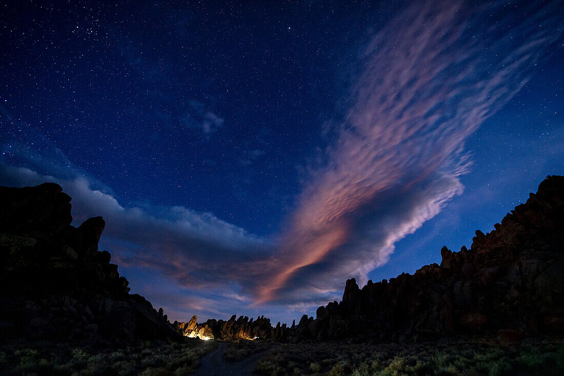 Campsites light up the jagged rocks at night; Lone Pine, California, United States of America