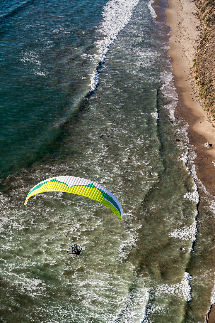 Aerial view of a paramotorer high above the California coastline; Carpinteria, California, United States of America