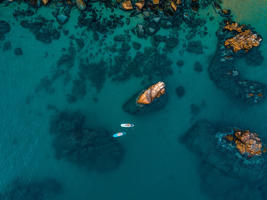 Aerial view of paddleboarders along the rocky shore on the East Cape of Cabo; Cabo San Lucas, Baja California Sur, Mexico