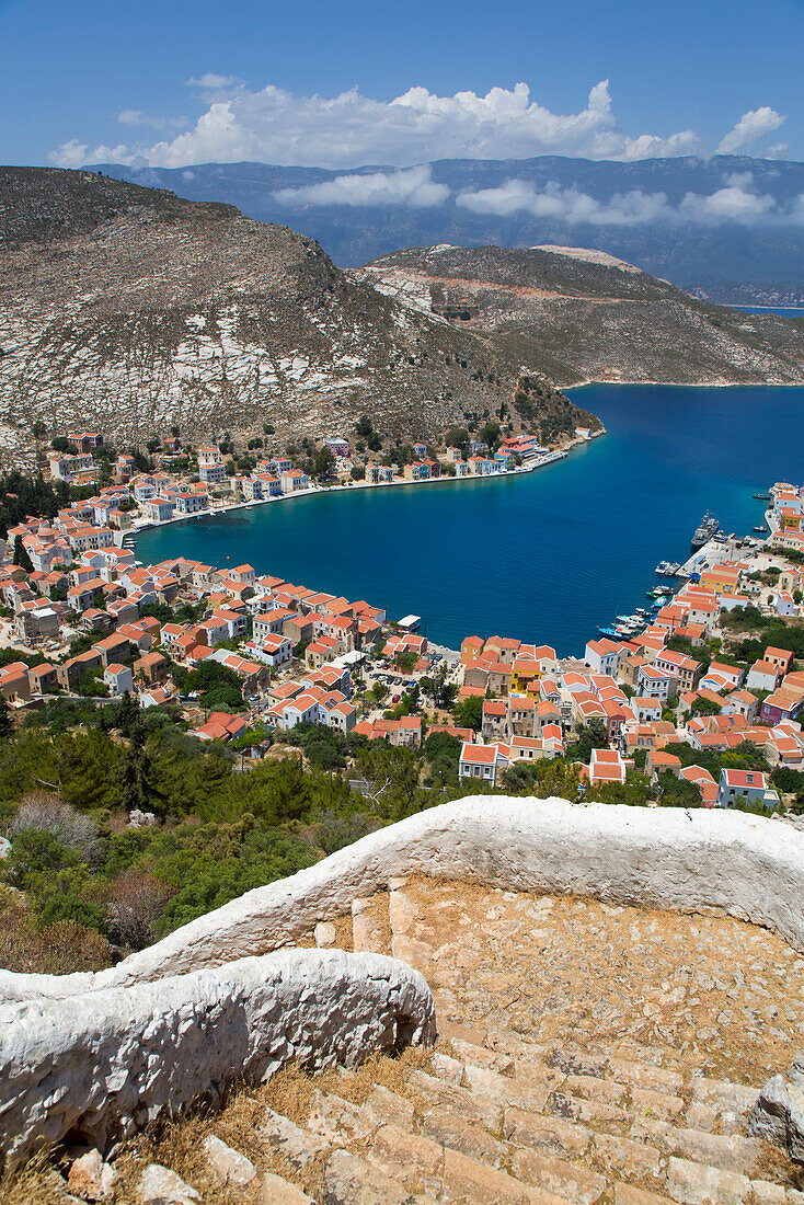 Cliff steps in the foreground looking down to a view of the harbor and town of Kastellorizo on the historical island of Kastellorizo (Megisti) Island; Dodecanese Island Group, Greece