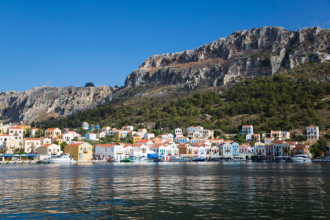 Traditional buildings and boats moored along the shore of the Kastellorizo Harbor on the historical island of Kastellorizo (Megisti) Island; Dodecanese Island Group, Greece