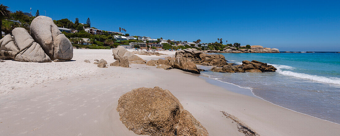 Häuser am Strand und große Felsbrocken am Atlantik am Clifton Beach; Kapstadt, Westkap, Südafrika
