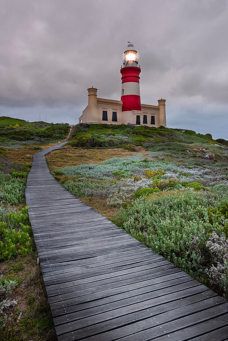 Wooden boardwalk across the moorland leading to the Cape Agulhas Lighthouse at Cape Agulhas, the Southern Most Point of the Continent of Africa and the maritime border of the Indian and Atlantic Oceans in Agulhas National Park; Western Cape, South Africa