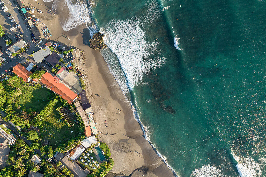 Drone aerial view of beach and buildings on the shoreline at Batu Bolong; Canggu, Bali, Indonesia