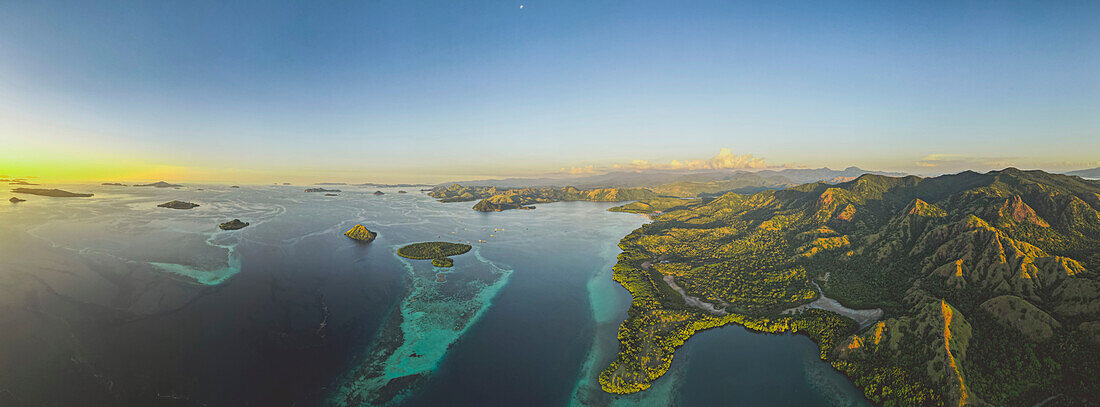 Aerial view of the Komodo Islands with bright yellow sunlight on the horizon, Komodo National Park, home of the famous Komodo Dragon; East Nusa Tenggara, Lesser Sunda Islands, Indonesia