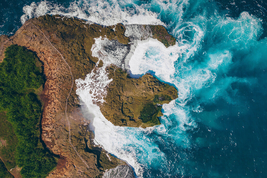 Blick von oben auf die felsige Küste von Nusa Lembongan mit dem türkisfarbenen Wasser der Bali-See, das gegen die Küste schlägt; Nusa Islands, Klungkung Regency, Ost-Bali, Bali, Indonesien