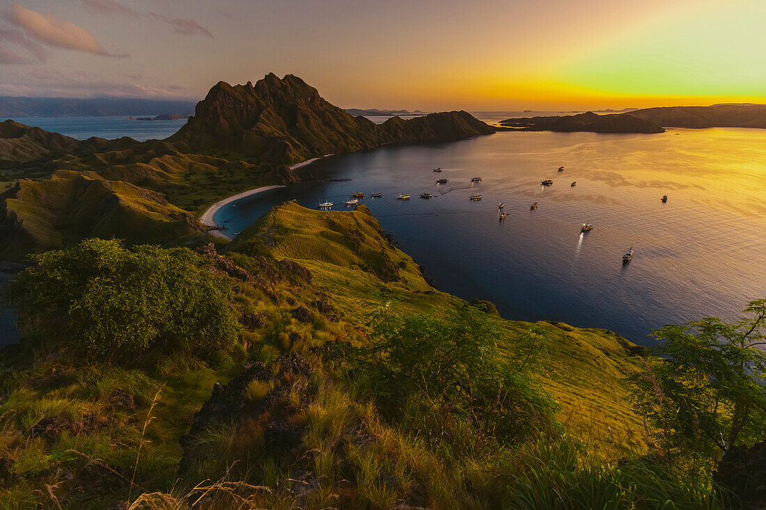 Boote in der Bucht von Padar Island im Komodo Nationalpark im Komodo Archipel im goldenen Licht des Sonnenuntergangs; Ost Nusa Tenggara, Indonesien